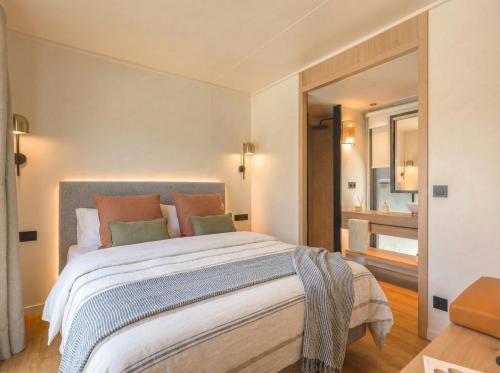 a bedroom with a large bed and a bathroom at L'Acciola in Evisa