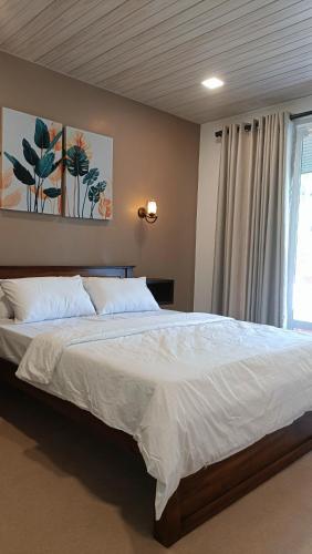 a bedroom with a large white bed with a window at Meneth Villa in Hatton