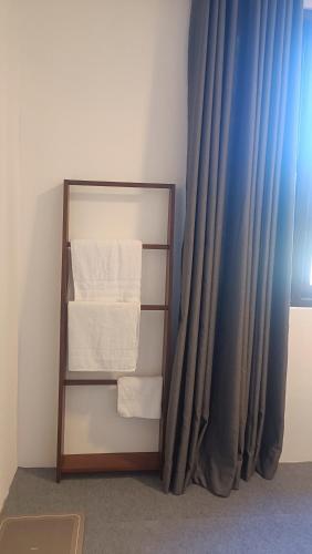 a towel rack with towels in front of a curtain at Meneth Villa in Hatton