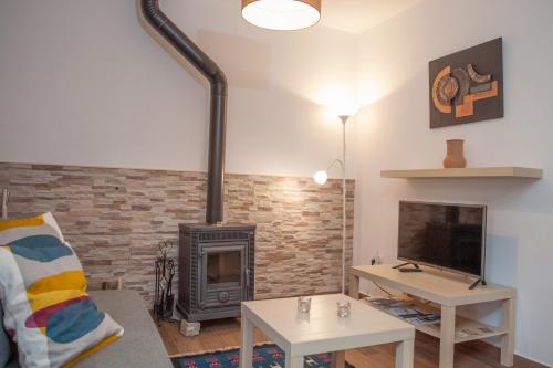 a living room with a fireplace and a tv at Moinhos do Pisão in Povoa Dao