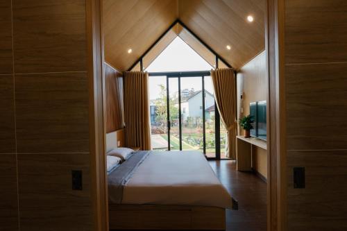 a bedroom with a bed and a large window at Zenora Homestay in Khu Chi Lăng