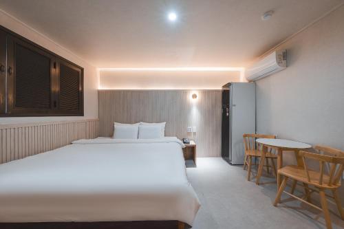 a bedroom with a bed and a table and chairs at Hotel ONYU Busan Sasang in Busan