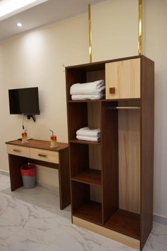 a room with a desk and a shelf with a television at Pr Pyramids Inn in Cairo