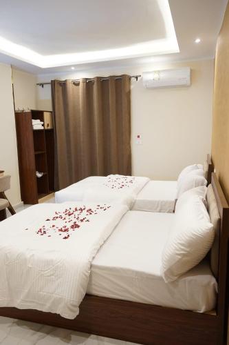 a bedroom with two beds with roses on the sheets at Pr Pyramids Inn in Cairo