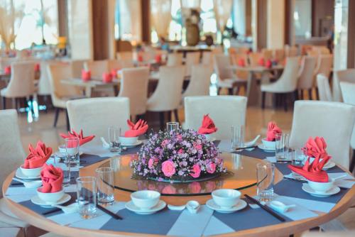 a table with a flower arrangement on top of it at Muong Thanh Luxury Ca Mau Hotel in Cà Mau