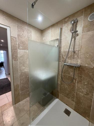 a shower with a glass door in a bathroom at La Baraque de Beauval in Saint-Aignan