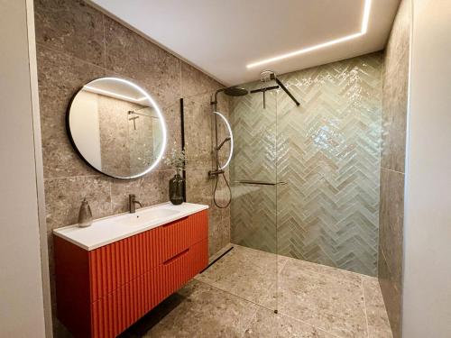 a bathroom with a red cabinet and a shower at La Rosière en Gaume in Musson