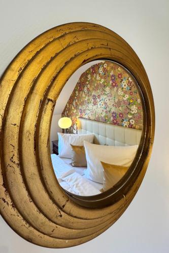 a large wooden mirror over a bed in a bedroom at Boutique Hotel Restaurant Hollerather Hof in Hellenthal