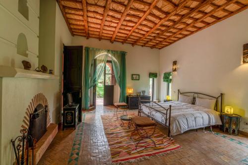a bedroom with a bed and a fireplace at Dar Mardan in El Aggada