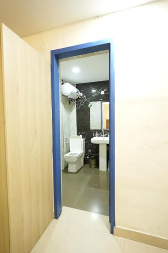 an open door to a bathroom with a toilet at Greek House By Housiify in Gurgaon