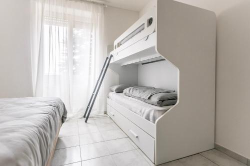 a white bedroom with a bunk bed and a window at Alpoggiouno in Vercurago