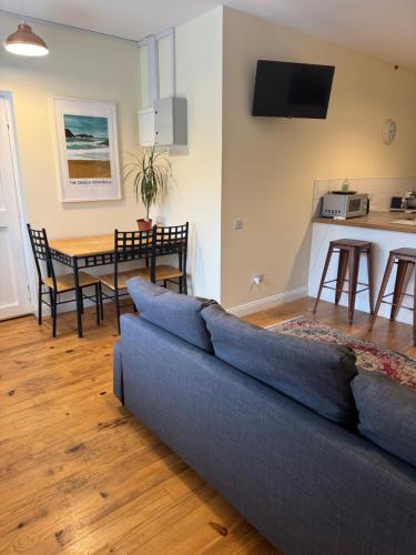 a living room with a blue couch and a table at Waterfront Apartment in Dingle