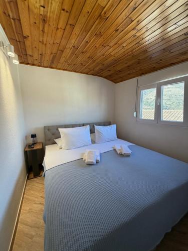 a bedroom with a large bed with a wooden ceiling at Verica in Dobrota