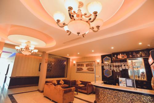 a living room with a chandelier and a couch at Muong Thanh Luxury Ca Mau Hotel in Cà Mau