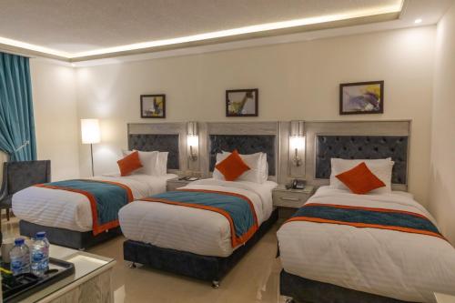 a hotel room with two beds with orange pillows at Petra Canyon Hotel in Wadi Musa