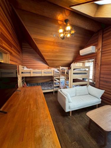 a living room with a couch and bunk beds at Attico Inn ムーミン公園近く in Hanno