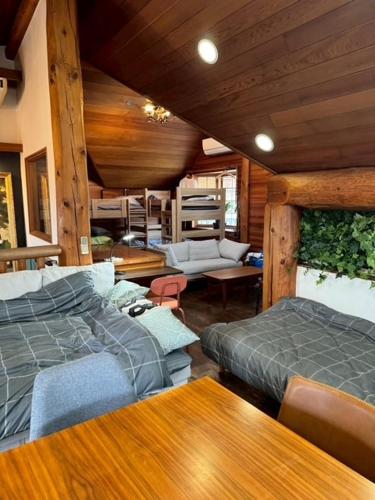 a bedroom with two beds and a living room at Attico Inn ムーミン公園近く in Hanno