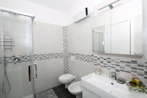 a bathroom with a toilet and a sink and a shower at Apartment A lago private beach and parking in Oliveto Lario