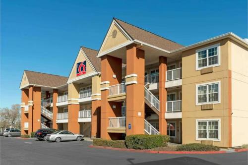 a large apartment building with cars parked in a parking lot at Studio 6 Extended Stay Sacramento Arden Way CA in Sacramento