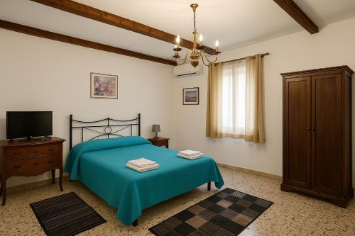 a bedroom with a blue bed and a television at Albergo Diffuso Borgo Santa Caterina "Vintage" in Castiglione di Sicilia