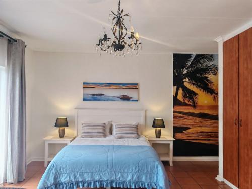 a bedroom with a bed and a chandelier at Sunset on Silver Beautiful self catering Studio apt in Roodepoort