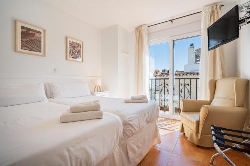 a bedroom with a bed and a chair and a window at Apartamentos Capricho del Mar in Torremolinos