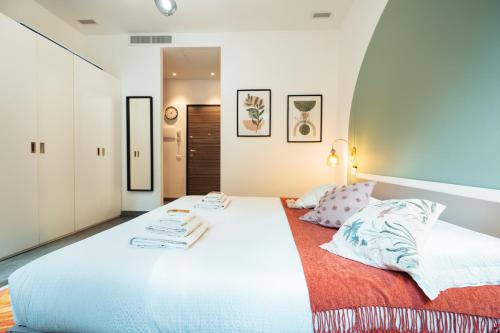a bedroom with a large white bed with towels on it at Cà del Lasco - Free parking apartments 5 min from the station in Bellano