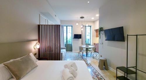 a bedroom with a bed and a living room at Heritage apartamentos in Villajoyosa
