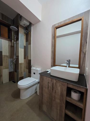 ein Badezimmer mit Waschbecken, Toilette und Spiegel in der Unterkunft The CRADLE in Daressalam