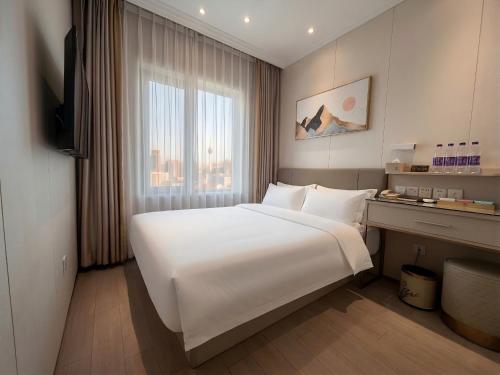 a large white bed in a room with a window at Inner Mongolia Hotel Beijing - 300m to CUC Metro, Easy Access to Forbidden City & Universal Studios in Beijing