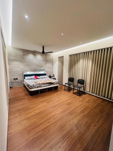 a bedroom with a bed and two chairs in it at Weekend villa in Rajkot