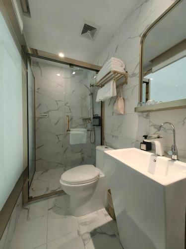 a bathroom with a toilet and a sink and a shower at Inner Mongolia Hotel Beijing - 300m to CUC Metro, Easy Access to Forbidden City & Universal Studios in Beijing