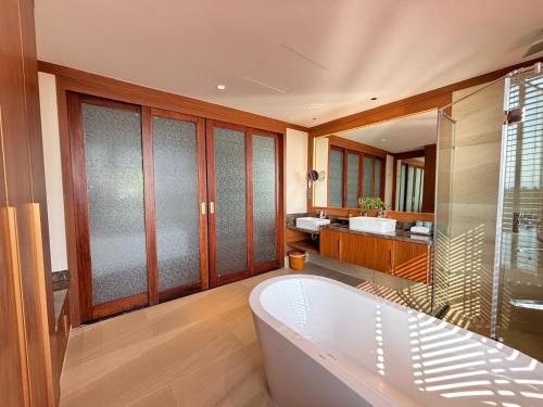 a large bathroom with a tub and a sink at Koi Resort & Spa Hoi An in Hoi An