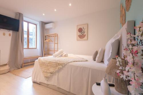 a white bedroom with a bed and a window at La Perle Bleue - air conditioning - ground floor in Bourg-en-Bresse