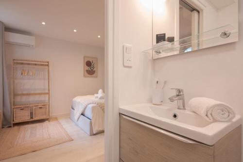 a bathroom with a sink and a bedroom at La Perle Bleue - air conditioning - ground floor in Bourg-en-Bresse