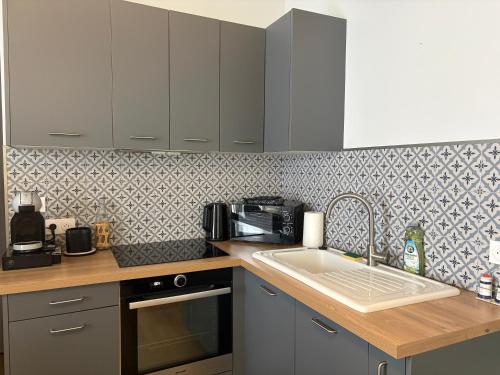 a kitchen with a sink and a microwave at Maison de charme centre Pornic in Pornic
