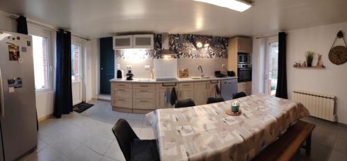 a kitchen with a table and chairs and a table and a kitchen at Chambre phare in Auderville