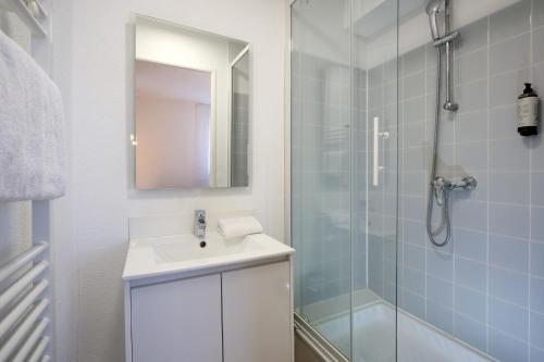 a bathroom with a sink and a shower with a mirror at Sweetly Isatis Mérignac Hôtel de ville in Mérignac