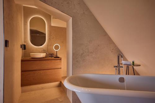 a bathroom with a white tub and a sink at Dikker & Thijs Hotel in Amsterdam