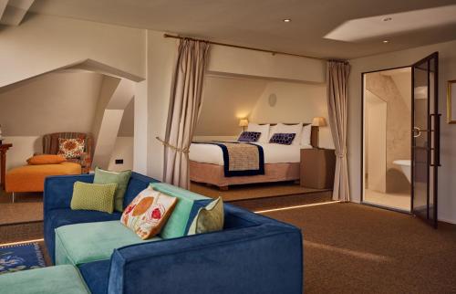 a living room with a bed and a blue couch at Dikker & Thijs Hotel in Amsterdam