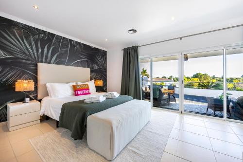 a bedroom with a large bed and a balcony at Burgau Sea View, Beach & Pool Villa in Budens