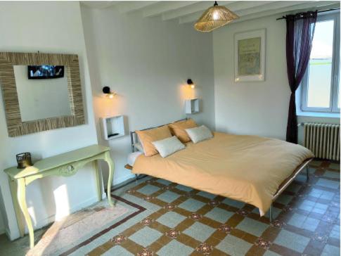 a bedroom with a large bed in a room at Le Jardin du saumon in Angé
