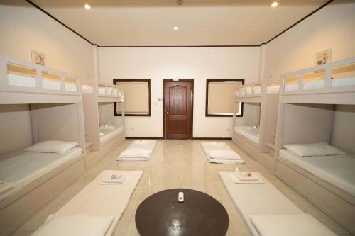 a room with four bunk beds and a table at Brevant Pool Club and Resort in El Salvador