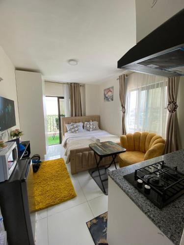 a kitchen and living room with a bed and a couch at Luxore Apartments Syokimau No E803 in Syokimau