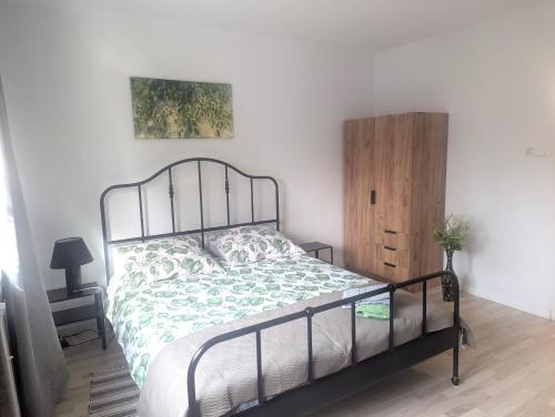 a bedroom with a bed and a wooden cabinet at Smart Centrum in Konin
