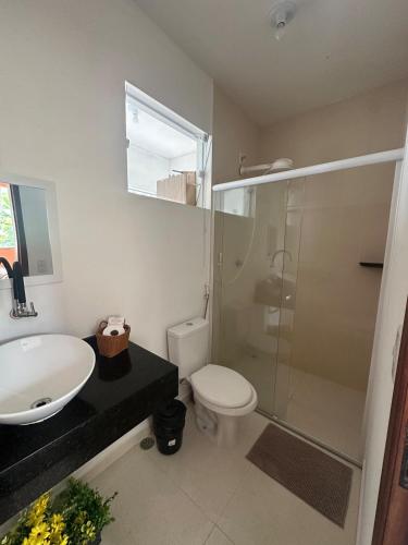 a bathroom with a sink and a toilet and a shower at Casinha da Val in Atibaia