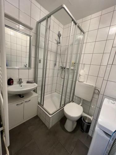 a bathroom with a shower and a toilet and a sink at Cityperle Apartment in Erfurt