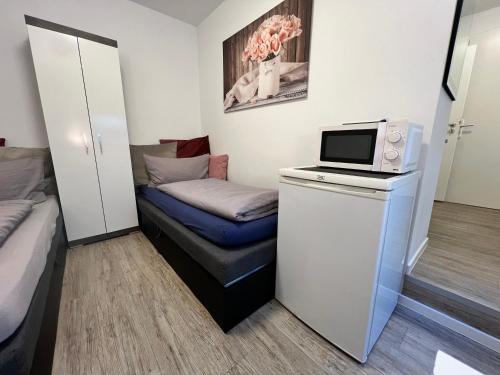 a small room with a bed and a microwave at Cityperle Apartment in Erfurt