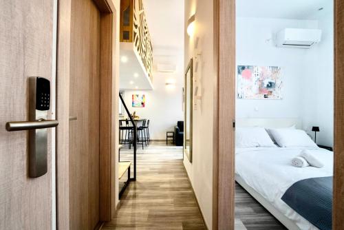 a bedroom with a bed and a hallway at Central Suites Aegina 1 in Egina