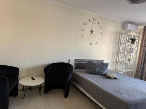 a bedroom with a bed and a clock on the wall at Apartments on Priportovaya,35 in Cherkasy